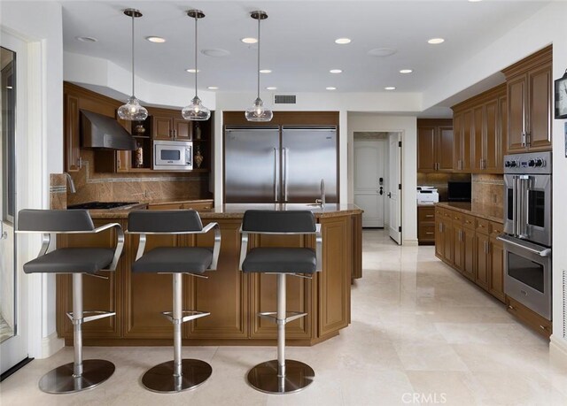 3824 Vista Blanca, San Clemente, CA 92672 - kitchen with built in appliances, wall chimney range hood, decorative backsplash, a breakfast bar area, and recessed lighting