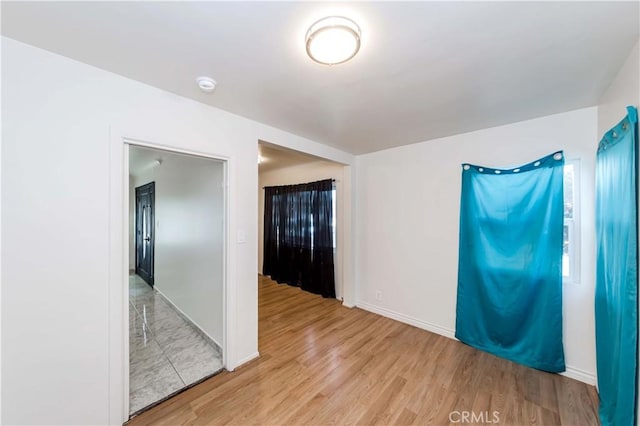 empty room with baseboards and wood finished floors