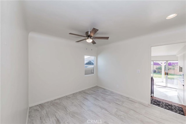 empty room with recessed lighting, a ceiling fan, and baseboards