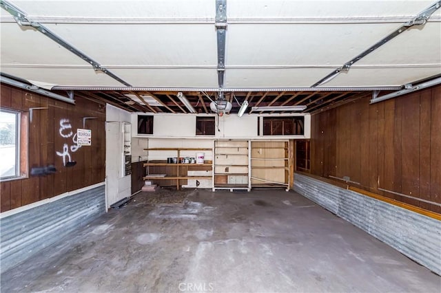 garage featuring wood walls and a garage door opener