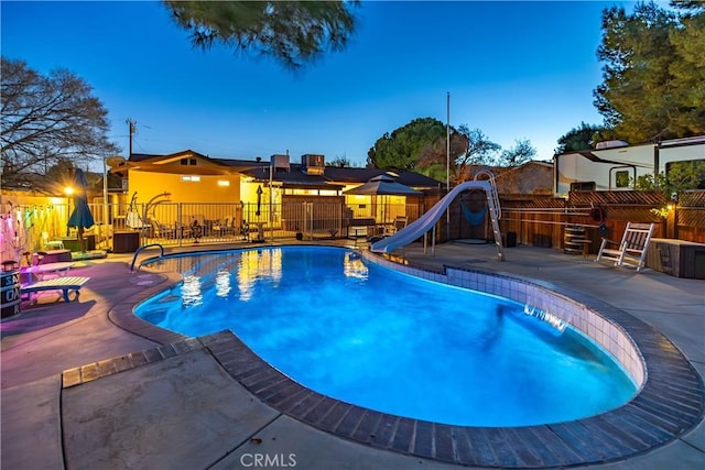 view of swimming pool with a fenced in pool, a water slide, fence, and a patio