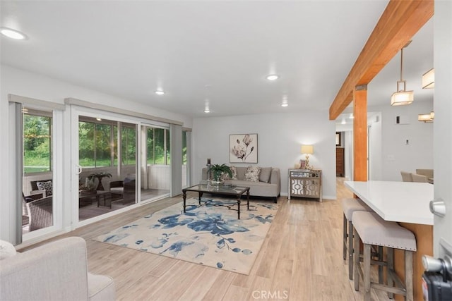 living area featuring light wood finished floors, beamed ceiling, and recessed lighting