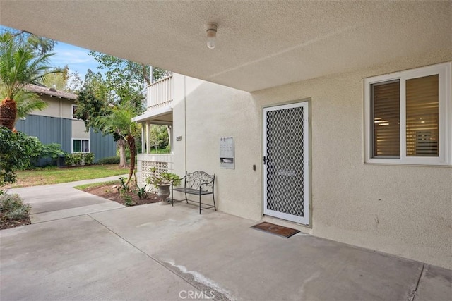 doorway to property featuring a patio and stucco siding