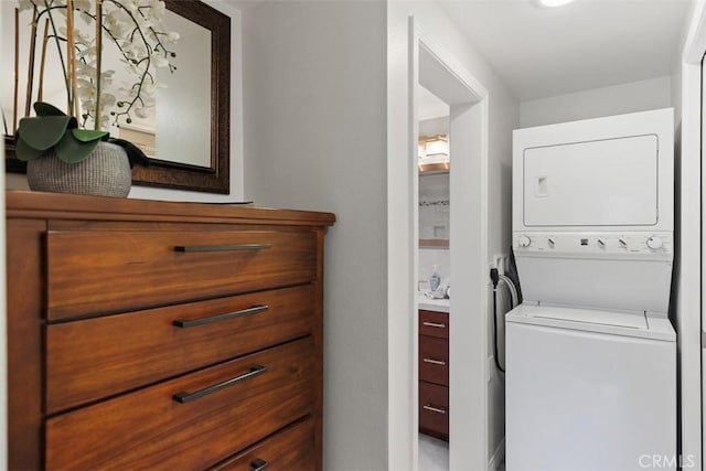 laundry area featuring stacked washer / drying machine and laundry area