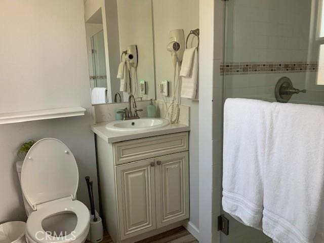 bathroom with vanity, toilet, and walk in shower