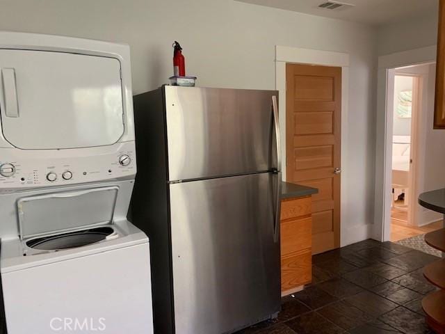 laundry room with stacked washer / dryer and visible vents