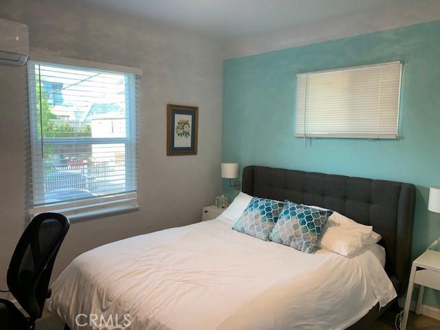 bedroom featuring a wall mounted air conditioner