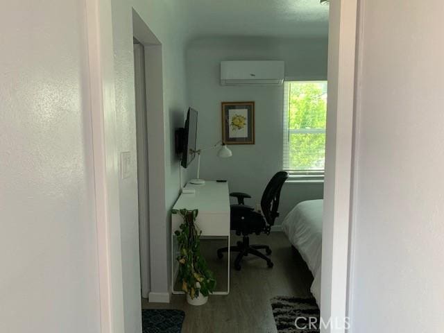 office space featuring an AC wall unit and wood finished floors