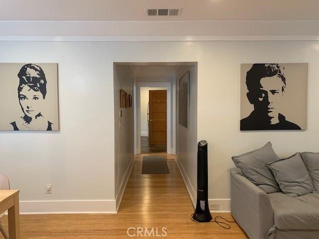 hallway with light wood-type flooring, baseboards, and visible vents