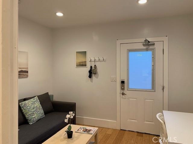 interior space with baseboards, light wood-style flooring, and recessed lighting