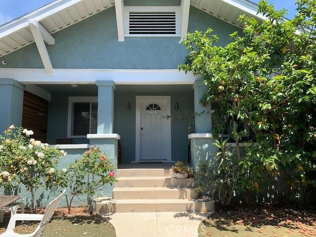 entrance to property with a porch and stucco siding