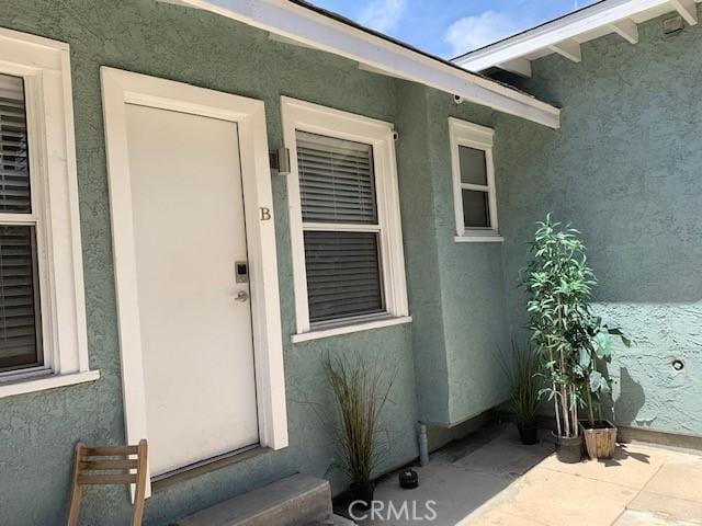 view of exterior entry with stucco siding