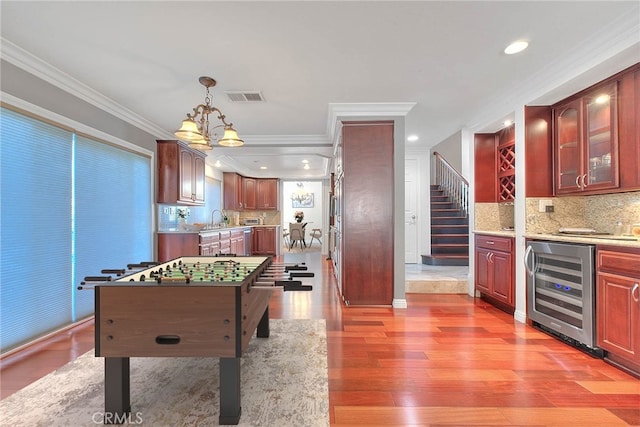 rec room featuring wine cooler, crown molding, recessed lighting, visible vents, and wood finished floors