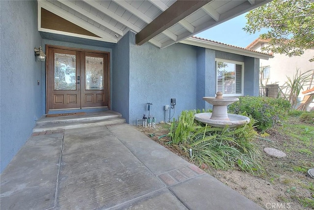 property entrance featuring french doors and stucco siding