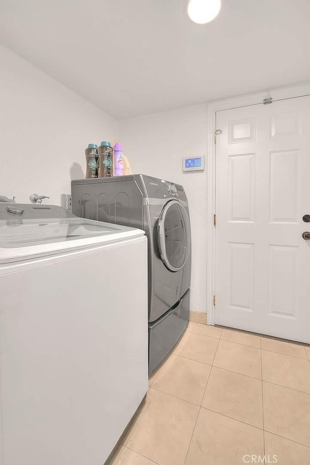 laundry room with washing machine and dryer, laundry area, and light tile patterned floors