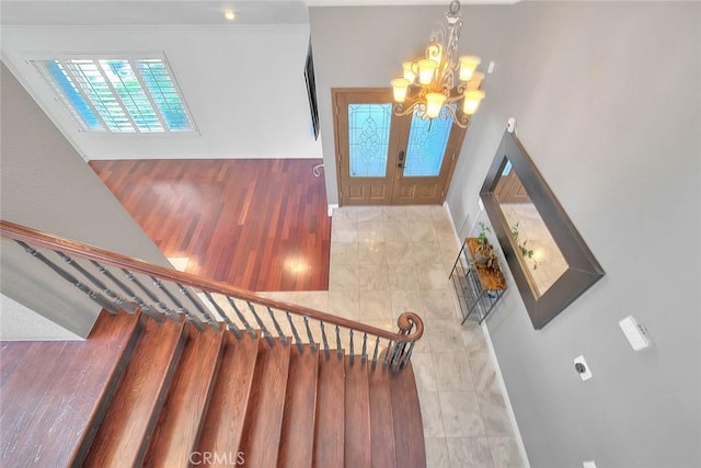 tiled entryway with baseboards, stairs, a chandelier, and ornamental molding