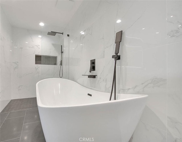 full bathroom featuring a freestanding tub, tile walls, and a marble finish shower