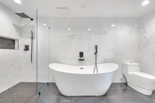 full bath with a freestanding tub, a marble finish shower, and tile patterned floors