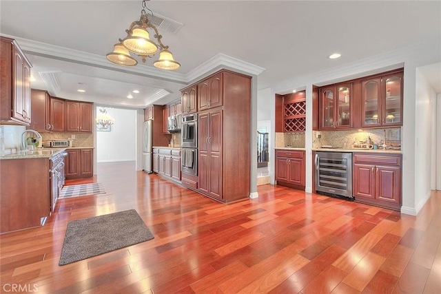 kitchen featuring light wood-style flooring, beverage cooler, appliances with stainless steel finishes, tasteful backsplash, and glass insert cabinets