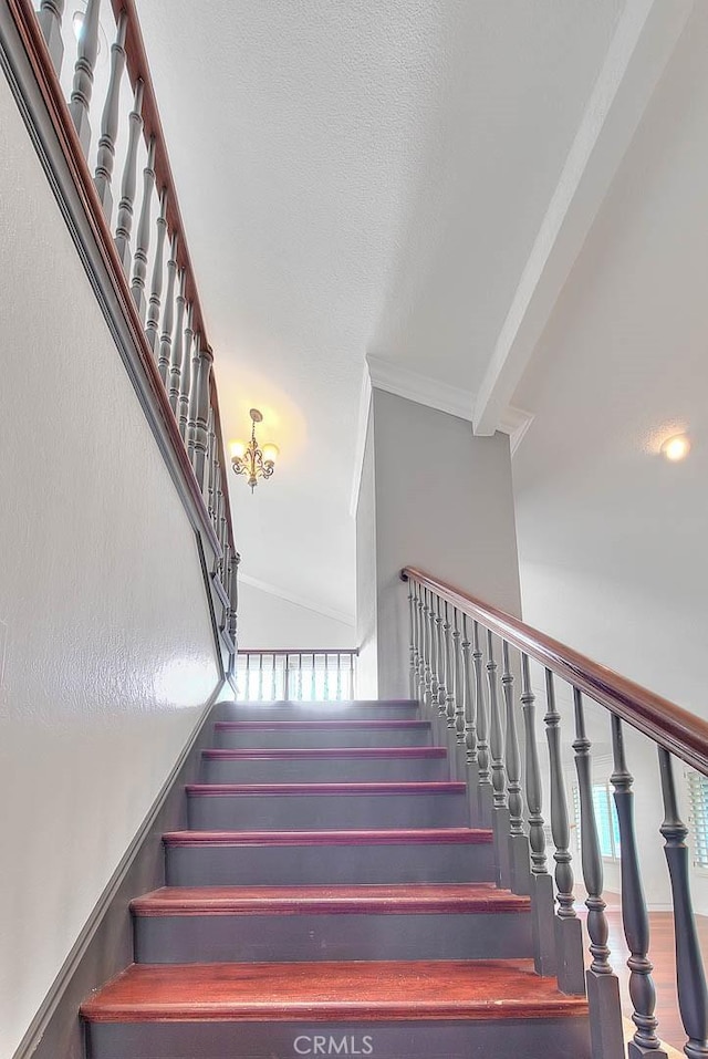 staircase with ornamental molding and plenty of natural light