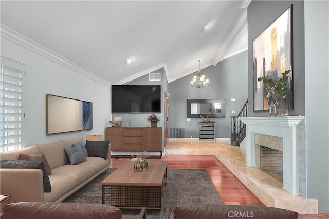 living area featuring vaulted ceiling, ornamental molding, wood finished floors, and visible vents