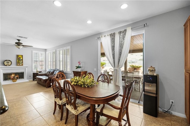 dining room with light tile patterned floors, recessed lighting, visible vents, baseboards, and a glass covered fireplace