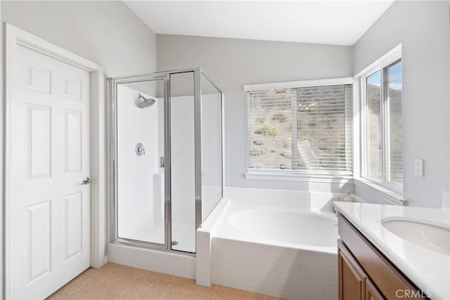 bathroom featuring vaulted ceiling, a garden tub, a shower stall, and vanity