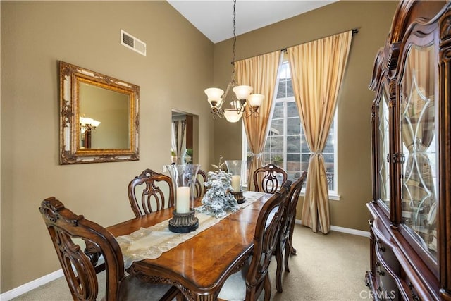 dining space with light carpet, baseboards, visible vents, an inviting chandelier, and vaulted ceiling