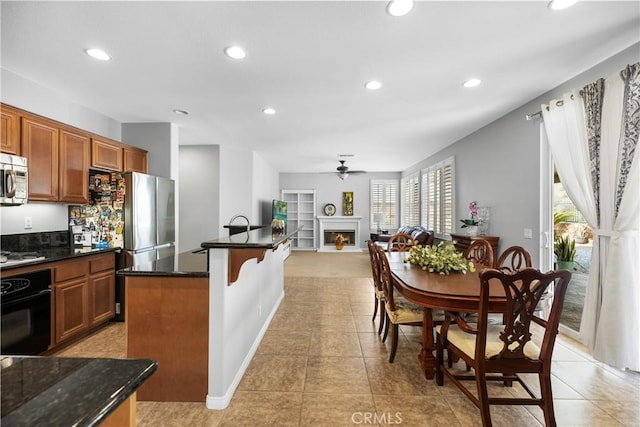 kitchen featuring a lit fireplace, stainless steel appliances, and recessed lighting