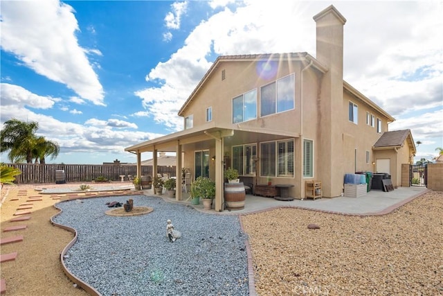 rear view of property featuring a patio, a fenced backyard, and stucco siding