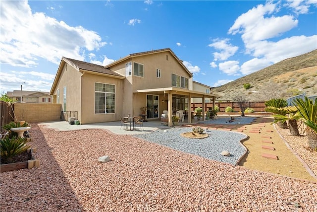 back of house with a patio area, a fenced backyard, and stucco siding