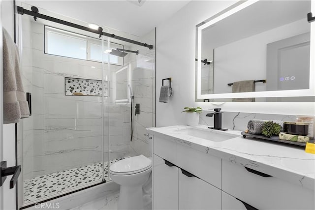 bathroom with toilet, marble finish floor, a marble finish shower, and vanity