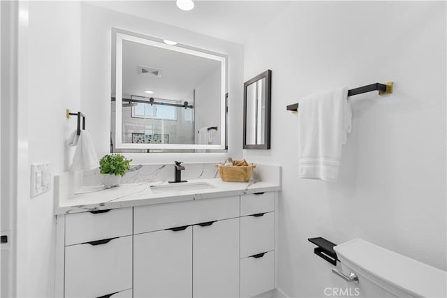 full bathroom with visible vents, vanity, toilet, and a shower with door