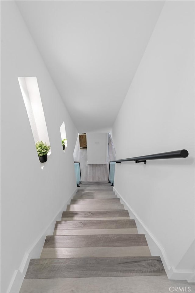 stairs with baseboards and wood finished floors