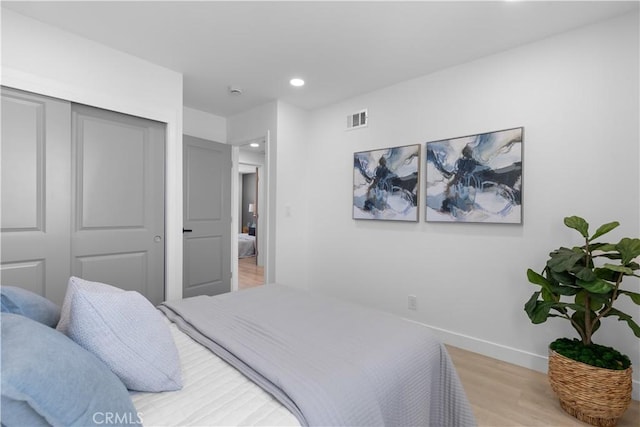 bedroom featuring baseboards, visible vents, wood finished floors, a closet, and recessed lighting