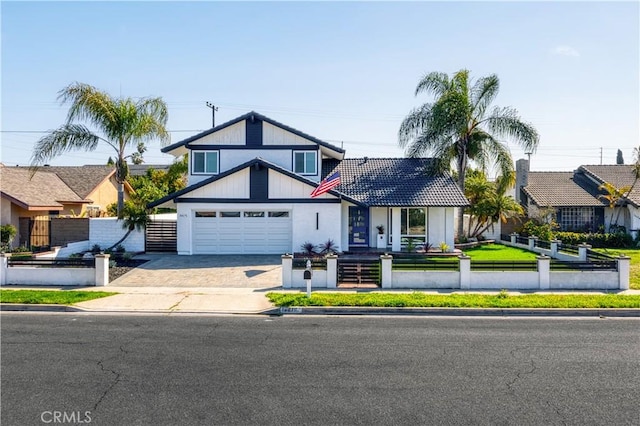 view of front of home with driveway, a fenced front yard, and an attached garage