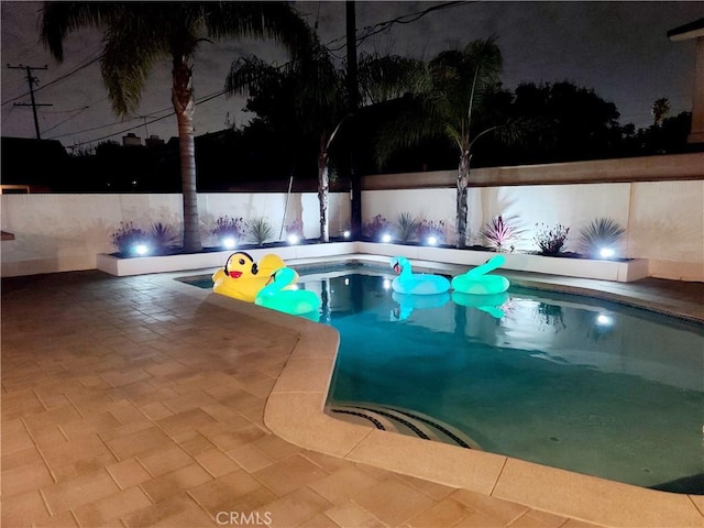 pool at twilight featuring a fenced in pool and a patio