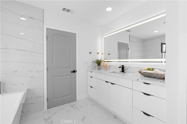 full bath featuring recessed lighting, vanity, visible vents, marble finish floor, and a soaking tub