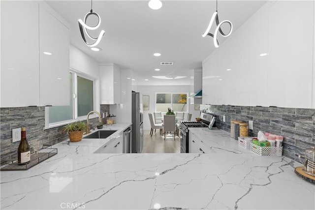 kitchen featuring white cabinets, modern cabinets, stainless steel appliances, and a sink