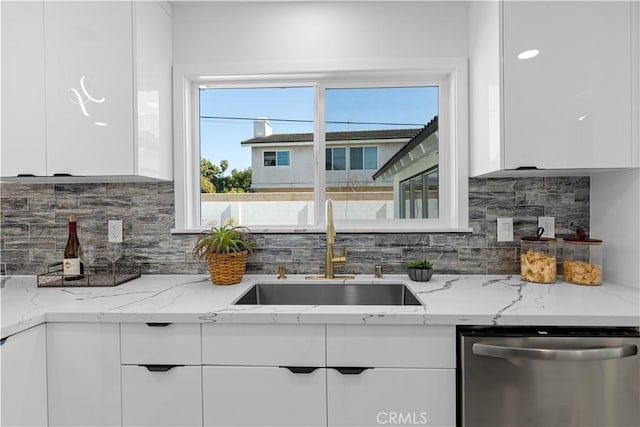 kitchen with tasteful backsplash, dishwasher, modern cabinets, white cabinetry, and a sink