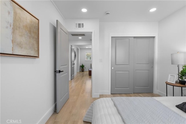 bedroom with light wood-style flooring, recessed lighting, visible vents, baseboards, and a closet