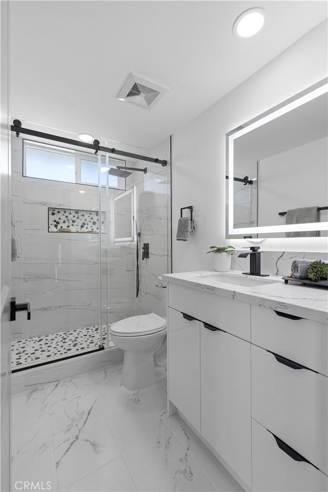 bathroom with toilet, vanity, visible vents, marble finish floor, and a marble finish shower