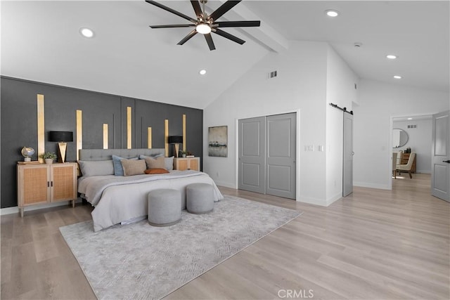 bedroom featuring high vaulted ceiling, a barn door, recessed lighting, light wood-type flooring, and beam ceiling