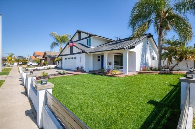 view of front of property featuring an attached garage, concrete driveway, a front yard, and fence