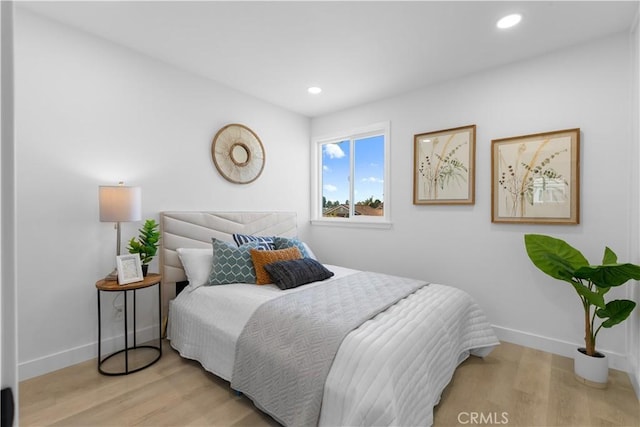 bedroom with baseboards, wood finished floors, and recessed lighting