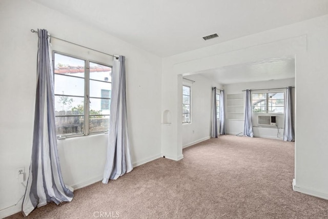 empty room with carpet flooring, baseboards, and visible vents