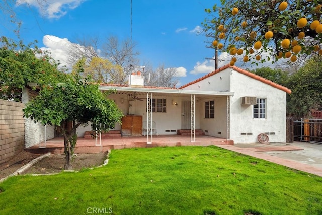 back of house featuring a patio, a wall unit AC, fence, a yard, and a chimney