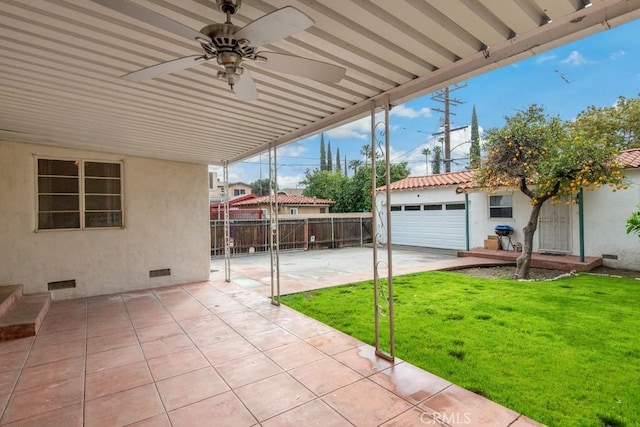 view of patio with an attached garage, ceiling fan, concrete driveway, and fence