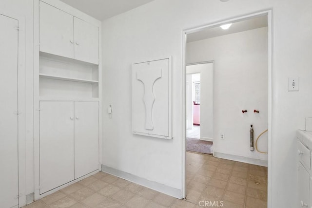 interior space featuring a closet, light floors, and baseboards