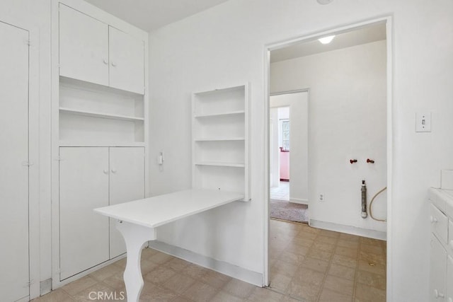 interior space featuring light floors and baseboards